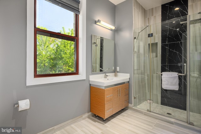 bathroom featuring a stall shower, vanity, and baseboards