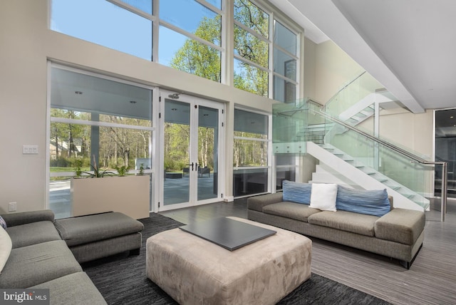 living area with stairway, french doors, and wood finished floors