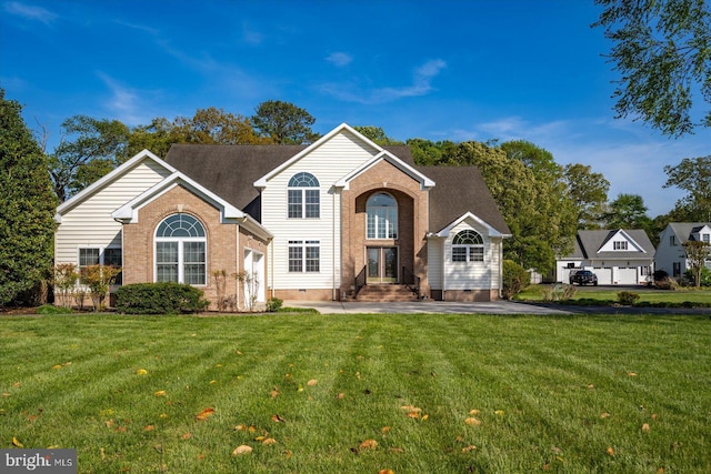 traditional-style house featuring brick siding, a front lawn, and crawl space