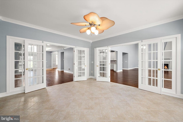 tiled spare room featuring french doors, ornamental molding, baseboards, and ceiling fan
