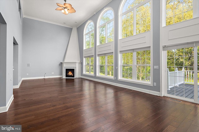 unfurnished living room featuring visible vents, a large fireplace, baseboards, wood-type flooring, and ornamental molding