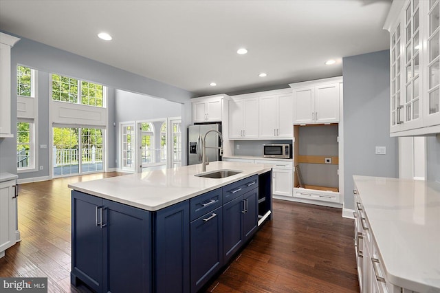 kitchen featuring dark wood-style flooring, white cabinetry, a sink, appliances with stainless steel finishes, and blue cabinetry