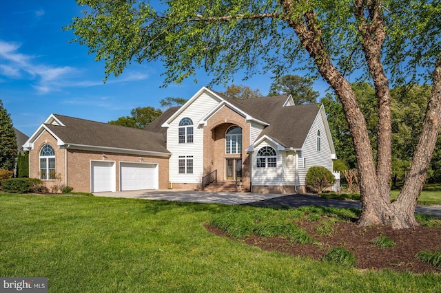 traditional home featuring driveway, roof with shingles, a front yard, a garage, and entry steps