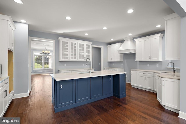 kitchen with a sink, white cabinets, custom exhaust hood, and dark wood-style floors