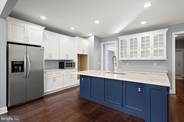 kitchen with appliances with stainless steel finishes, light countertops, a sink, white cabinetry, and dark wood-type flooring