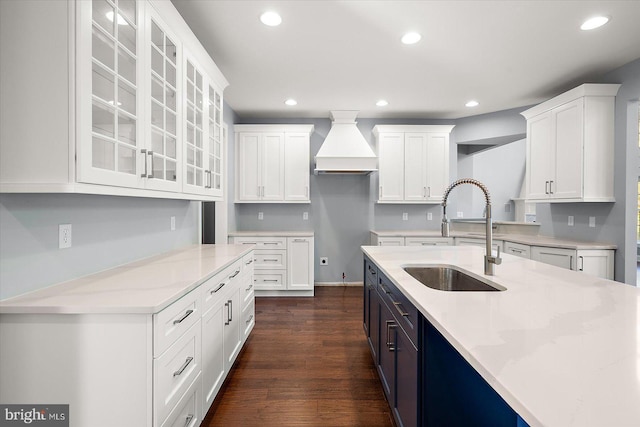 kitchen with recessed lighting, a sink, white cabinetry, and glass insert cabinets