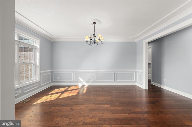 unfurnished dining area featuring crown molding, wainscoting, a notable chandelier, and hardwood / wood-style flooring