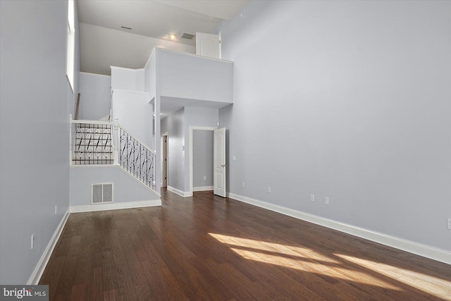 unfurnished living room featuring stairs, baseboards, visible vents, and wood finished floors