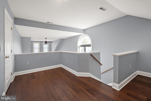corridor featuring baseboards, an upstairs landing, wood finished floors, and visible vents