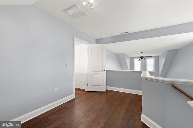 unfurnished room with dark wood-style flooring, baseboards, and visible vents