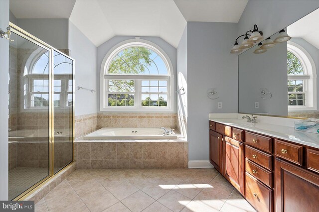 full bath with tile patterned flooring, a stall shower, lofted ceiling, and vanity