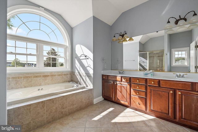 full bathroom with double vanity, lofted ceiling, a bath, tile patterned floors, and a stall shower