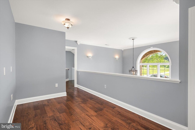 unfurnished room featuring baseboards, ornamental molding, and wood finished floors