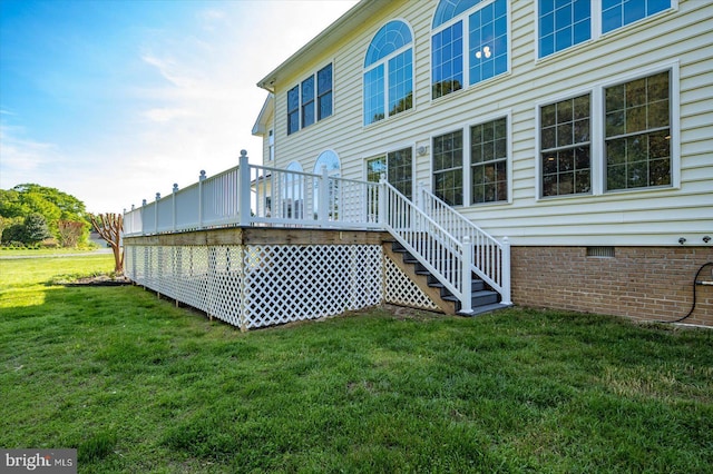 back of property featuring a lawn, a wooden deck, stairs, and crawl space