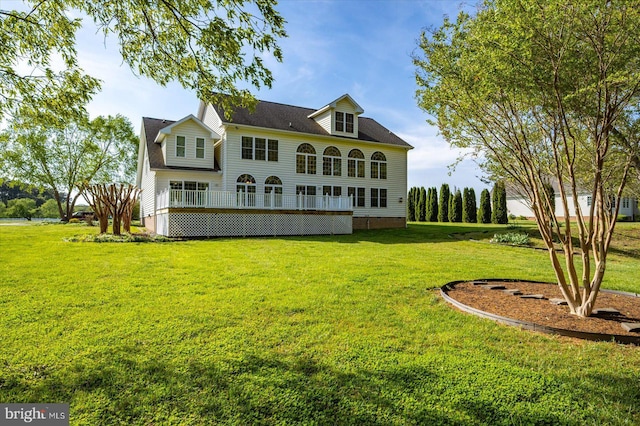 back of property featuring a lawn and a wooden deck