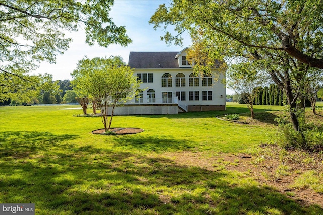 rear view of house with a lawn and crawl space