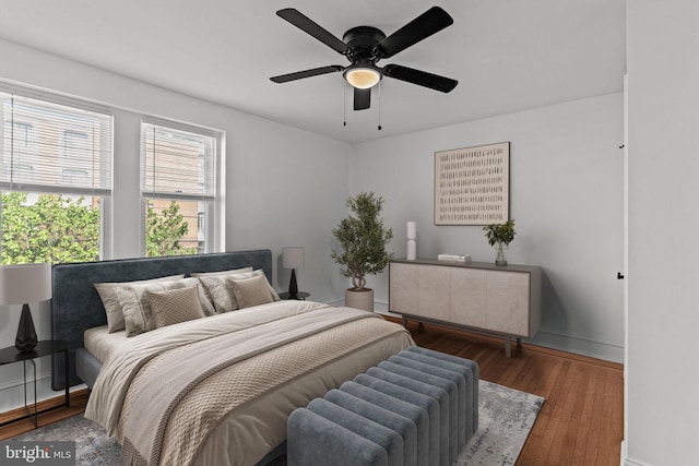 bedroom featuring baseboards, ceiling fan, and wood finished floors