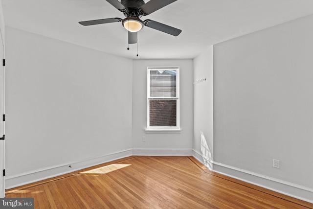 spare room with baseboards, a ceiling fan, and light wood finished floors