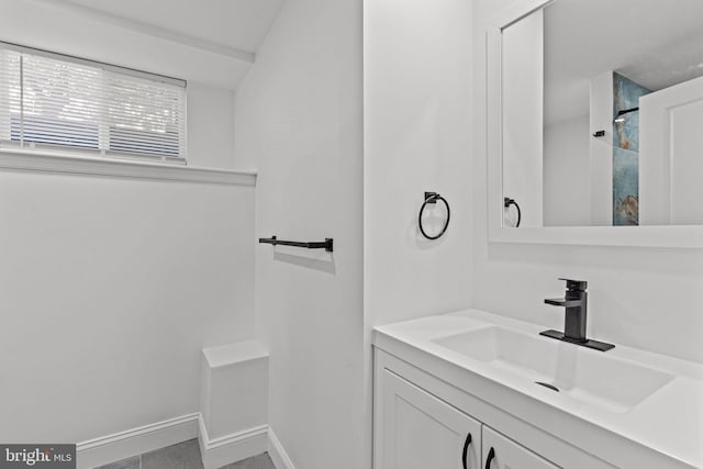full bath with baseboards, walk in shower, and vanity