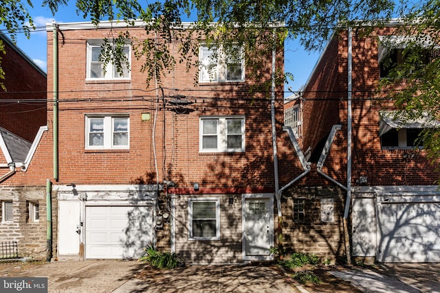 view of front of property with a garage, driveway, and brick siding