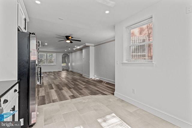 interior space with arched walkways, recessed lighting, baseboards, a ceiling fan, and wood finished floors