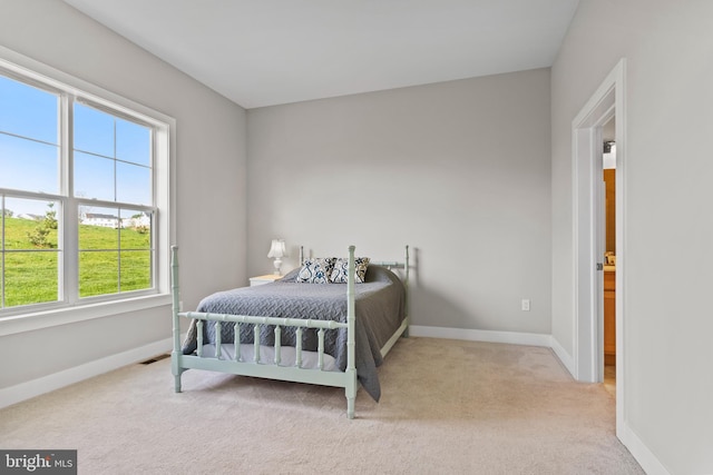 bedroom featuring baseboards, visible vents, and light carpet