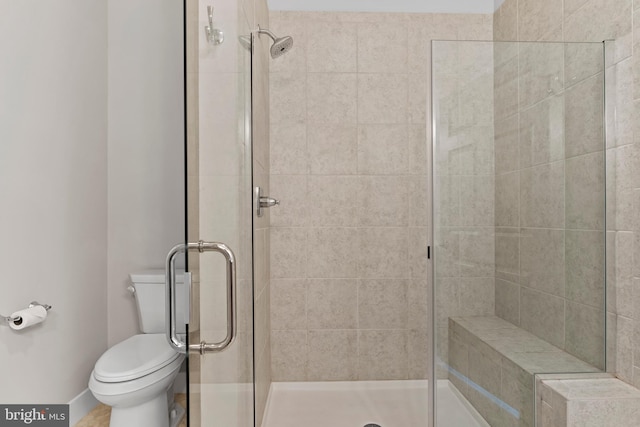 full bathroom with baseboards, a stall shower, and toilet