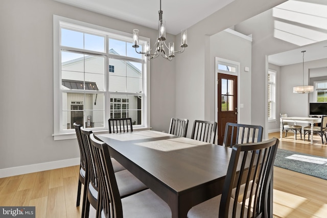 dining room featuring wood finished floors, a chandelier, and a healthy amount of sunlight