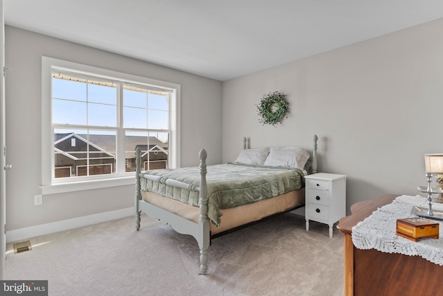 bedroom with baseboards and light carpet