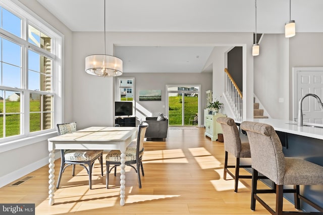 dining area with stairs, baseboards, visible vents, and a healthy amount of sunlight
