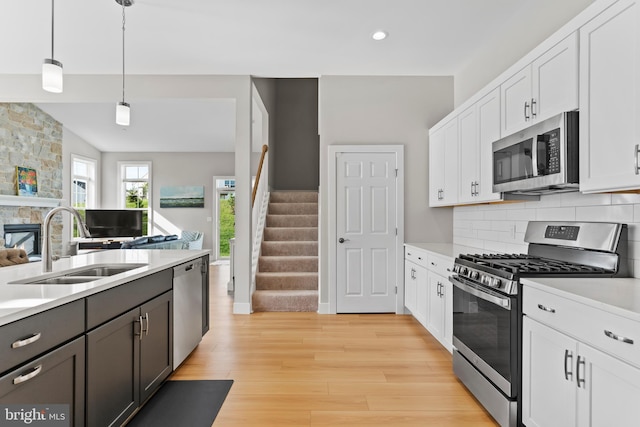 kitchen featuring light wood-style floors, a sink, light countertops, and stainless steel appliances
