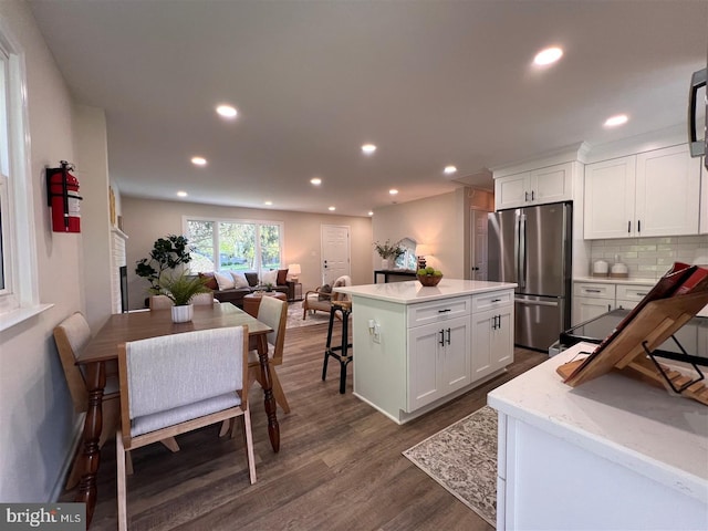 kitchen featuring dark wood finished floors, freestanding refrigerator, recessed lighting, and white cabinetry