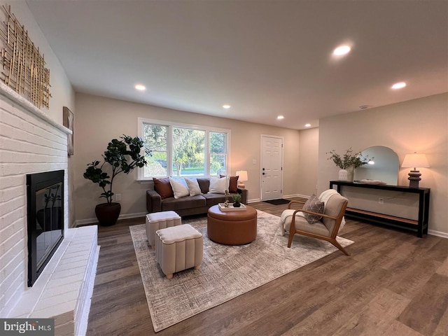 living area with recessed lighting, baseboards, wood finished floors, and a fireplace