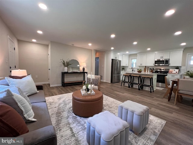 living room with recessed lighting, baseboards, and dark wood finished floors