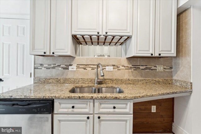 kitchen featuring dishwasher, a sink, white cabinets, and decorative backsplash