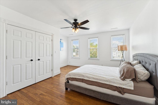 bedroom with multiple windows, hardwood / wood-style floors, baseboards, and ceiling fan