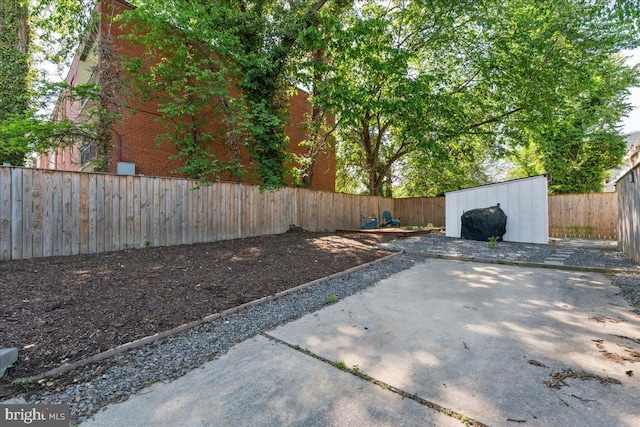 view of patio / terrace featuring a fenced backyard, an outdoor structure, and a storage shed