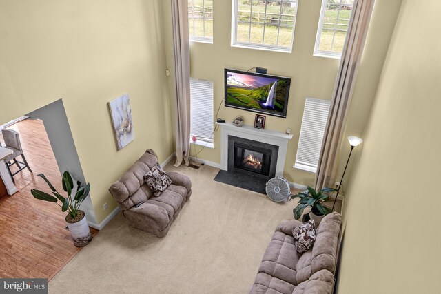 54 Durham Ln, Smyrna, DE 19977 - carpeted living room featuring a fireplace with flush hearth, baseboards, plenty of natural light, and a towering ceiling