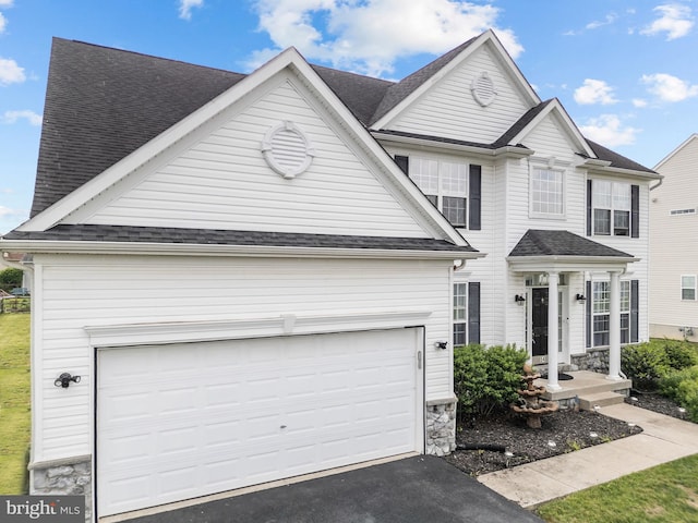 54 Durham Ln, Smyrna, DE 19977 - traditional-style house with roof with shingles, asphalt driveway, an attached garage, and stone siding