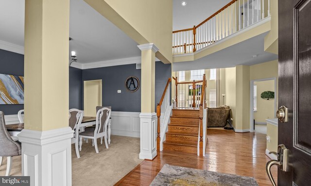 54 Durham Ln, Smyrna, DE 19977 - foyer entrance featuring decorative columns, ornamental molding, stairway, wood finished floors, and a wainscoted wall