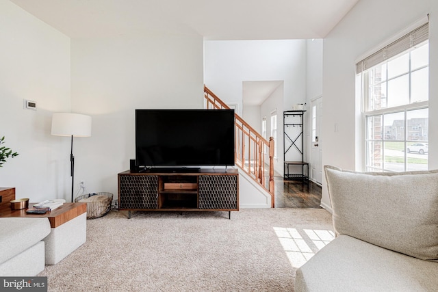 carpeted living area featuring stairway