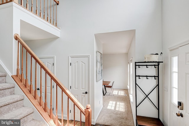 stairs with baseboards and a towering ceiling