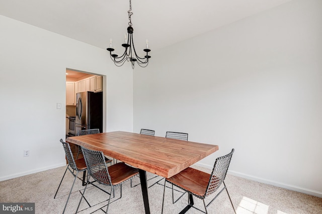 dining area featuring baseboards, light carpet, and a notable chandelier