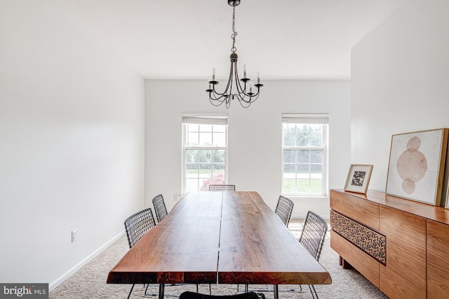 dining space with baseboards, an inviting chandelier, and carpet