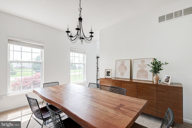 dining space with an inviting chandelier, baseboards, carpet floors, and visible vents