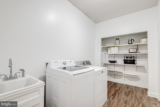 washroom with a sink, laundry area, dark wood-style floors, and washer and clothes dryer