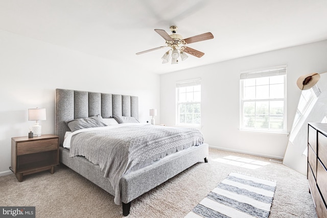 bedroom with baseboards, light carpet, and a ceiling fan