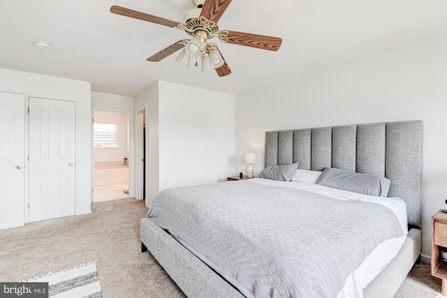 bedroom with ceiling fan, connected bathroom, and light colored carpet