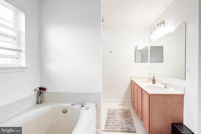 full bath featuring double vanity, a sink, and a bath
