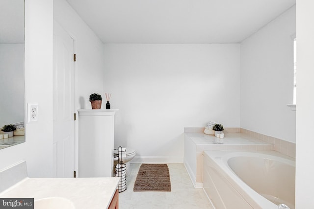 full bath featuring vanity, baseboards, a bath, and toilet